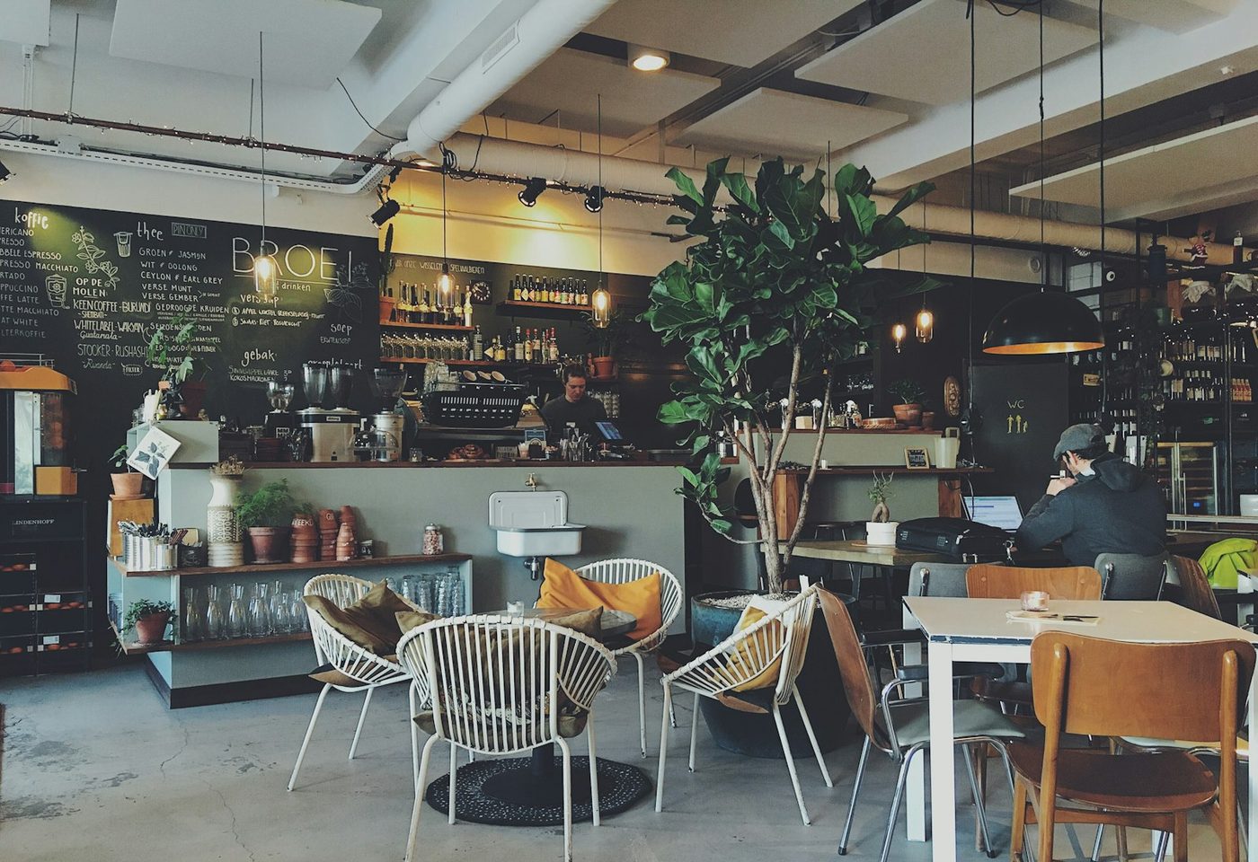 Meja bar kafe dengan mesin kopi dan pelanggan